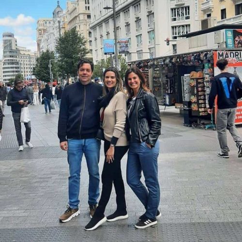 Thais e um casal de amigos estão posando para uma foto no meio do passeio.